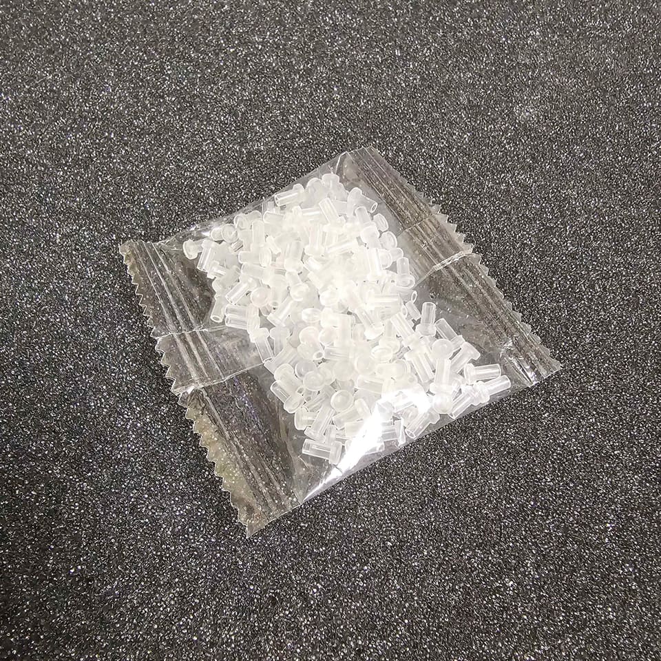 A sealed bag of 200 clear dust caps on carpet